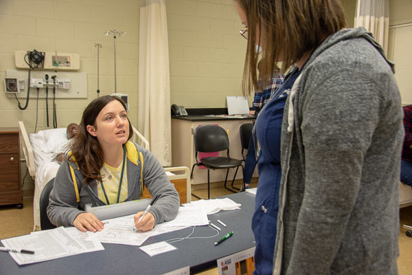 Melissa Edmonds, family/community outreach specialist for STEP Head Start, playing the role of a social service agency, gauges a student role player’s financial needs and eligibility for government assistance. The student is Kiara N. Meiser, of Lock Haven.