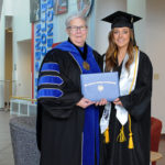 Butler receives her diploma from President Gilmour.