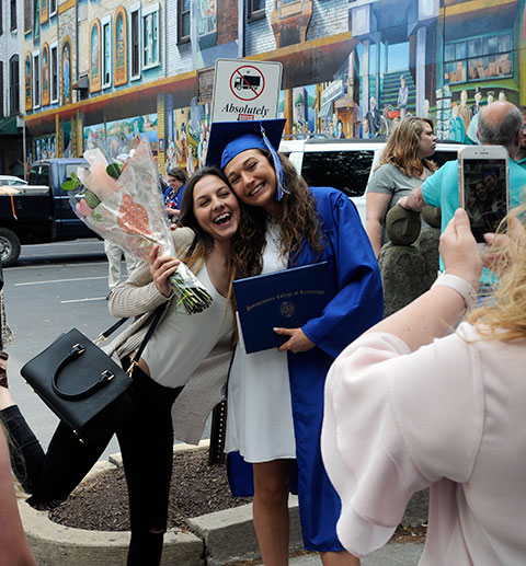 Stephanie L. McGinness, who earned an associate degree in business management, marks the occasion with friend and studio arts student Wita Dominika Kuglasz.