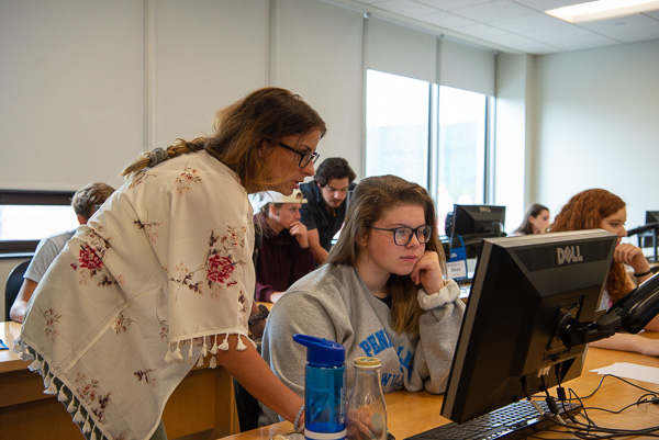 Penn College students Olivia A. Kleman (standing at left) and Riley A. Ferro (standing in background) assist Architecture Odyssey campers. Kleman and Ferro, enrolled in building science and sustainable design, returned to campus as camp assistants for their major.