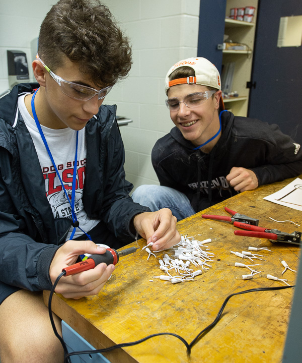 In an electrical lab at the Aviation Center, students learn to tin wires with solder as part of building a working electrical circuit.