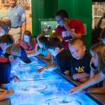 Museum visitors check out the Global Connections "touch table," which offers a compelling visual of Little League's international reach.