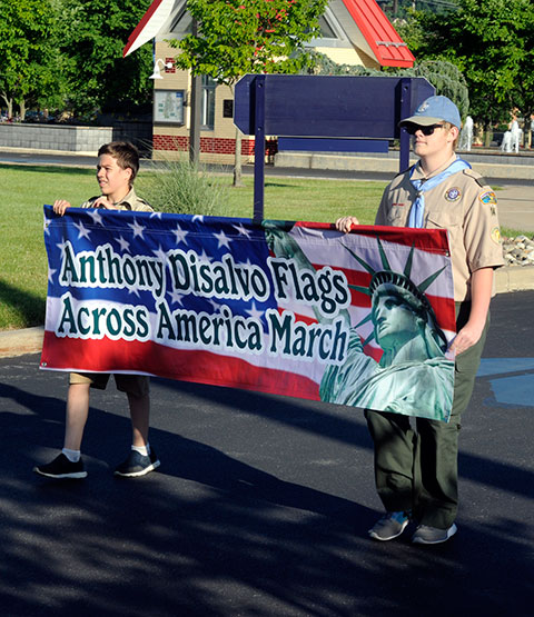 Scouts lead the procession with a banner reflecting the event's new name.