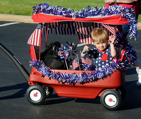Young Oliver Duitch waves from his star-spangled conveyance ... 