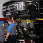 Robert B. Black, of Whitefish, Mont., talks with classmates before lowering the cab on a Ford F-250 ...