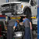 Students finish their work on a Ford F-550 before reconnecting the vehicle's halves.