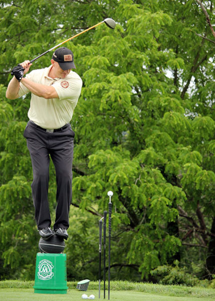 Trick shot performer Chuck “The Hit Man” Hiter dazzles a Williamsport Country Club crowd by maintaining his balance – and his eye on the ball – from a precarious perch.