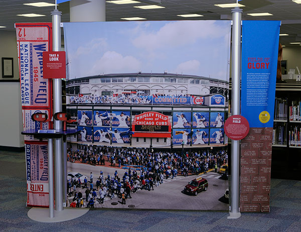 A Major League Baseball landmark for more than a century, Chicago's Wrigley Field is depicted in a tableau that invites fans to look through a viewer at stereoscopic pictures of America's great stadiums.
