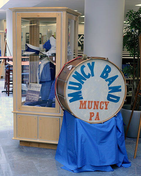 A 1910 Muncy Band drum, once bought at auction and used as a family's coffee table in Florida, is emblematic of the link between interscholastic athletes and the band members who support them. 
