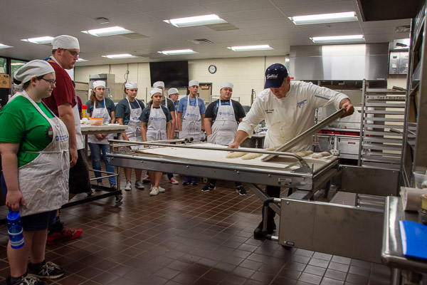 Chef Todd M. Keeley, instructor of baking and pastry arts/culinary arts, demonstrates to Future Restaurateurs how to load bread into an MIWE Condo Deck Oven.