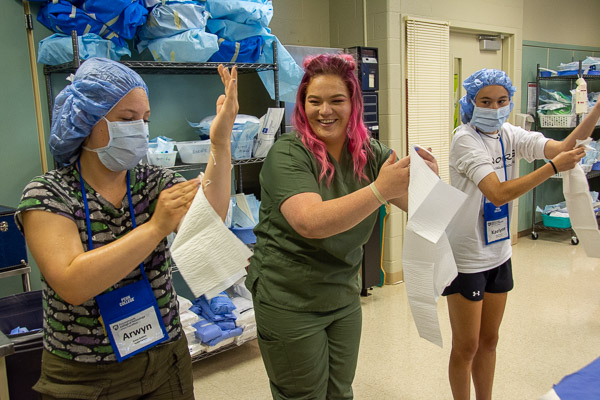 Surgical technology student Danika M. Paige (center) shows participants how to scrub for surgery.