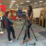 Physician assistant student Reshma Sherpa, of Morrisville, N.C., is interviewed Wednesday by Morgan Parrish near Madigan Library's "Hometown Teams" exhibit.