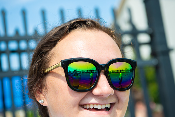 A friend’s peace signs and the brilliance of a new semester are reflected in the glasses of RA Christine A. Limbert. 