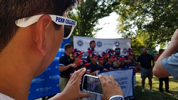 Sporting Penn College sunglasses, Joey M. Morrin, of Morrisville, snags a photo of the Mid-Atlantic team's banner moment.