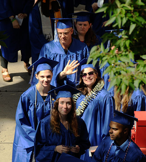 Graduates, who processed from the nearby Liberty Arena, acknowledge a photographer from alongside the Sun-Gazette building on West Fourth Street.
