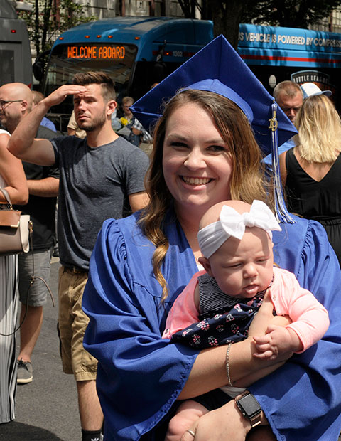 Elissa Stine celebrates her achievement – an associate degree in occupational therapy assistant – with a well-wisher's daughter.