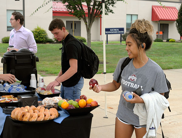 Students find first-day sustenance at a Wildcat Welcome station outside the Keystone Dining Room, one of four set up across campus by Dining Services and staffed by encouraging college employees. Among those on hand at this oasis were Residence Life coordinators Terrance E. Davis (background) and Blaise E. Marshall, and Counseling Services' Brian J. Schurr.