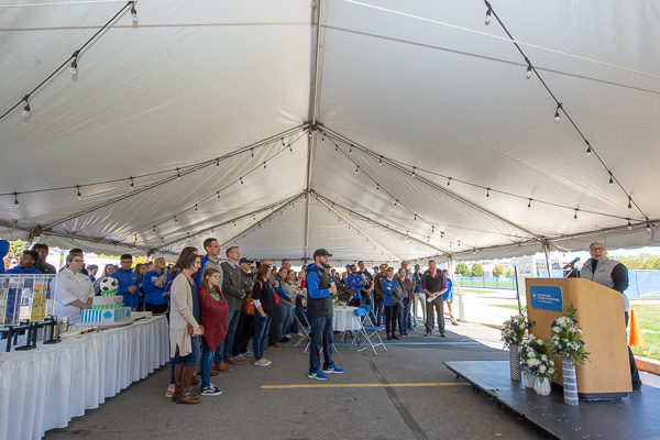 A large crowd, including Wildcat Club members, student athletes and business and industry partners, gathers under a tent to hear remarks by the college president (at podium) and UPMC Susquehanna’s president before the official dedication ceremony on the UPMC Athletic Field.