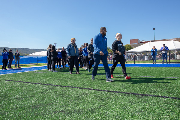 Making their way onto the field for the dedication ceremony are Ramel Newerls (front left), PepsiCo key account manager; women’s soccer forward Morgan Brooks (front right); and Amy Brooks (behind Newerls), vice president of sales, Susquehanna Trailways. 