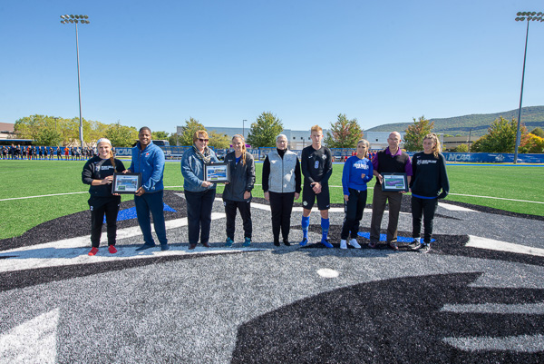 Penn College soccer players presented the college’s corporate partners with framed collages recognizing their support of UPMC Field and the enhanced athletic complex. Gathered at midfield for dedication ceremonies are (from left) Morgan Brooks, of Bellefonte; Ramel Newerls, key account manager for Pepsi; Amy Brooks, vice president of sales for Susquehanna Trailways; Tiffany Brown, of Mechanicsburg; Penn College President Davie Jane Gilmour, Chris R. McFarland, of Coatesville; Tayla E. Derr, of Selinsgrove; UPMC President Steven Johnson; and Francesca M. Timpone, of Smithtown, N.Y.