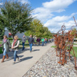 A long line of secondary educators and counselors make their way down the campus mall on a beautiful autumn day, led by Bradley M. Webb (far left), assistant dean of industrial, computing and engineering technologies.