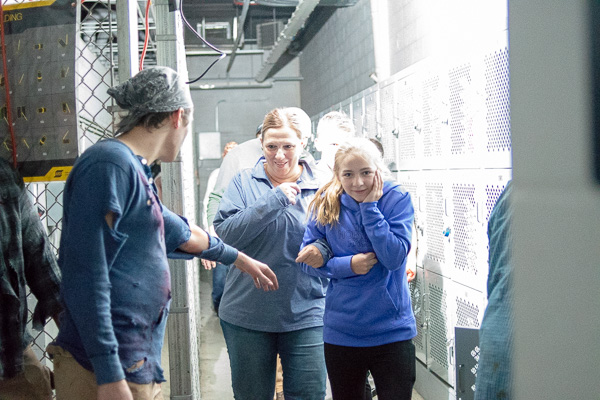 A group tentatively makes its way along a creepy corridor.