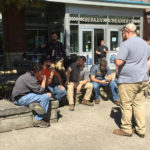 Evan Cleary (in plaid shirt), who arranged the campus visit as facilities manager in Penn State's Office of Physican Plant, joins his guests outside the famed Berkey Creamery. Cleary is a 2017 alumnus of Penn College's heating, ventilation and air conditioning technology major.