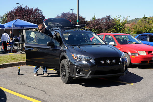 Mitchell J. Berninger, a 2017 graduate in web and interactive media, polishes his 2018 Subaru Crosstrek at the charity car show.