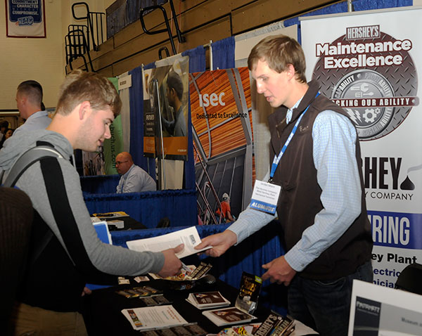 Jordan D. Mann (right), a 2018 graduate in welding and fabrication engineering technology, discusses career possibilities at Hershey Foods.