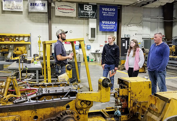 Laboratory assistant Seth J. Welshans assists a family touring the ESC's diesel facilities ...