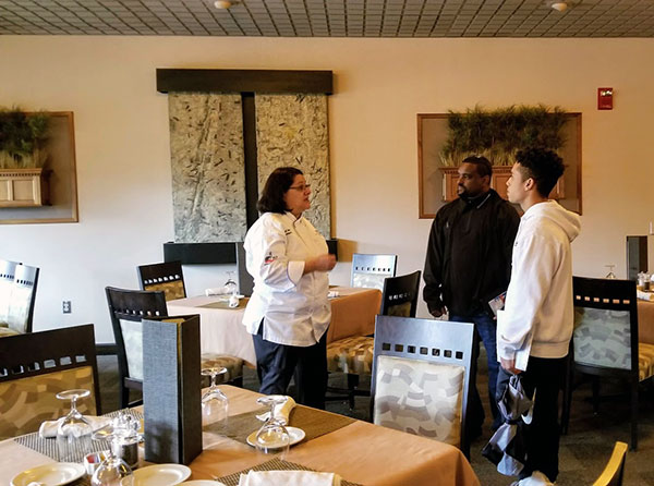 A family joins Mary G. Trometter, assistant professor and department head of hospitality management/culinary arts, in Le Jeune Chef's dining room.