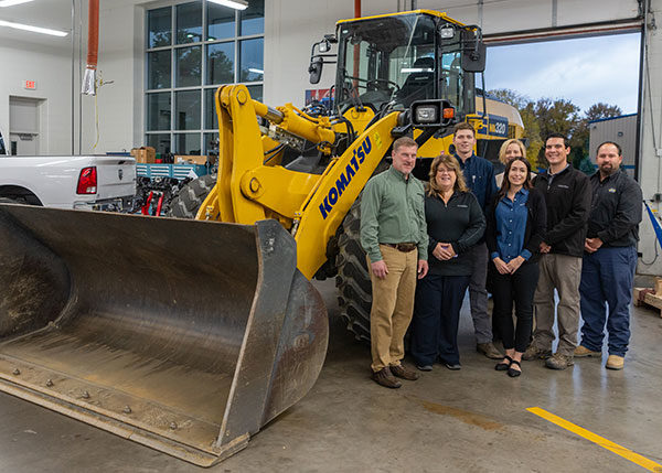 Standing before a WA320 wheel loader during its display on main campus – one of three pieces of equipment on loan from Komatsu to Pennsylvania College of Technology – are (from left) Mark Hufcut, Komatsu general manager; Holly Bodnar, marketing manager; student Joseph C. Moore, a heavy construction equipment technology: operator emphasis major from Lock Haven; Elizabeth A. Biddle, Penn College's director of corporate relations; Donna Evans, regional recruiter for Komatsu; Dave Eister, director of training; and Ryan W. Peck, instructor of diesel equipment technology at the college.