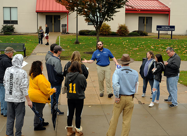 With a break in the clouds and umbrellas closed for the day, Presidential Student Ambassador Travis J. Scholtz embarks on a much-drier campus tour than earlier.