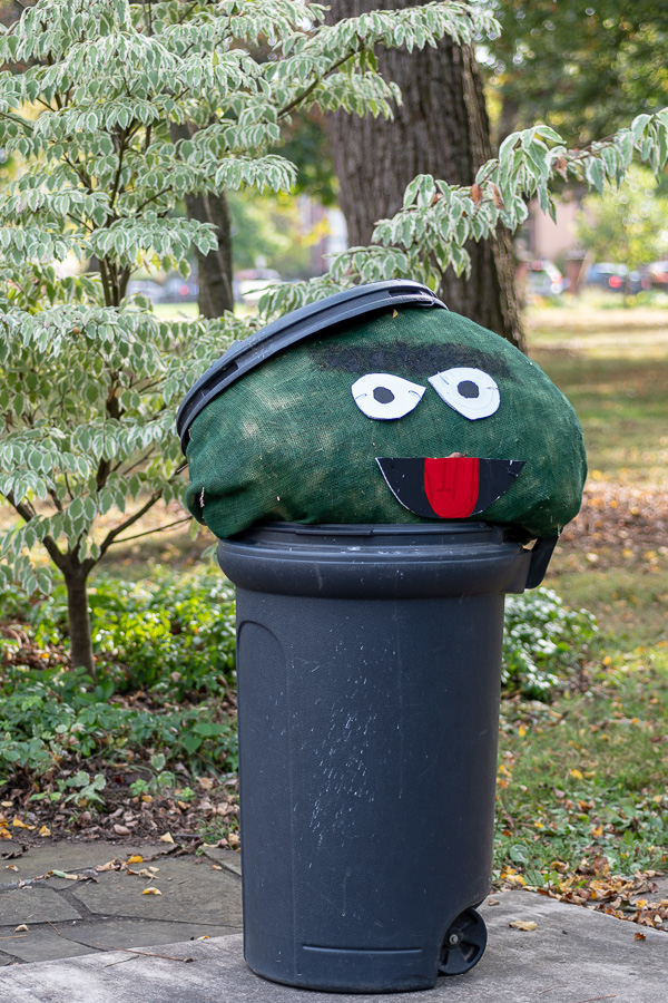 Temporarily relocated from Sesame Street, Oscar the Grouch peers out of his trademark trash can to survey a city landmark.
