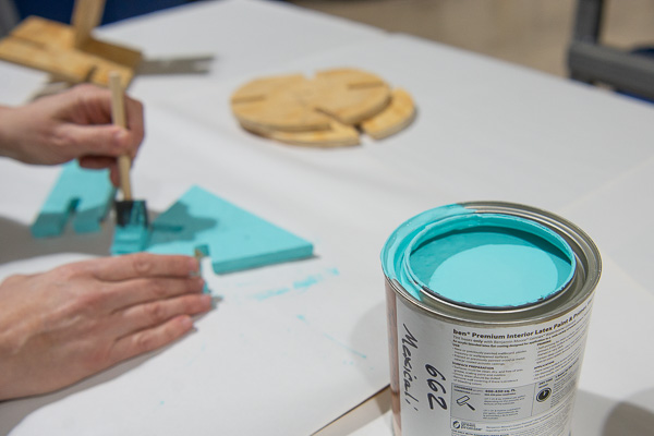 A cool blue hue is applied to an art educator’s wood sculpture pieces.