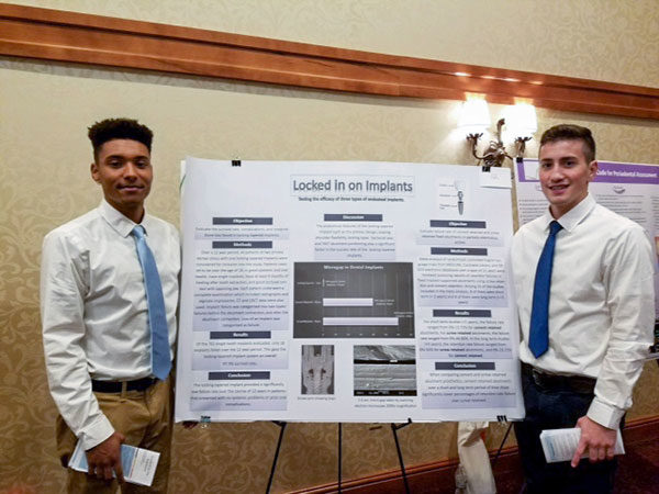 Pennsylvania College of Technology dental hygiene students Tyler J. Wetzel-Haynes (left), of Ono, and Pavel Dariychuk, of Leola, present their fourth place-winning poster, “Locked in on Dental Implants” at the Keystone Dental Health Conference in Kind of Prussia.