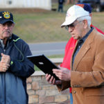 Markley (left) listens as Howard Wilt, a Marine veteran of the Korean War and chair of the memorial commission, reads the award inscription.