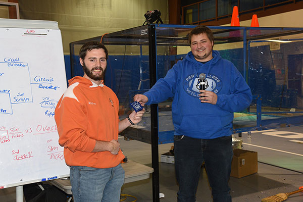 McCray accepts his third-place trophy from SWORD's Stanley L. Bohenek, also enrolled in the engineering design technology major,