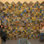 Santaella (left) and Kreitzer stand with the stunning tile wall. 