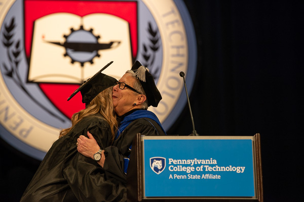 After turning Petrison's tassel, the president warmly embraces the class representative.