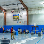 ... arcing her ball toward one of the trash-can "cups" in play.