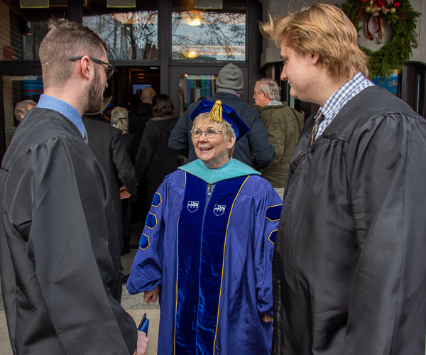Sandra L. Karnes, assistant professor of speech communication-composition, receives thanks from newly minted graduates.