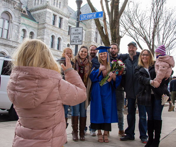 A young fan – and future photographer? – captures Lindsay M. Fox, a surgical technology graduate from Williamsport, with her friends and family.