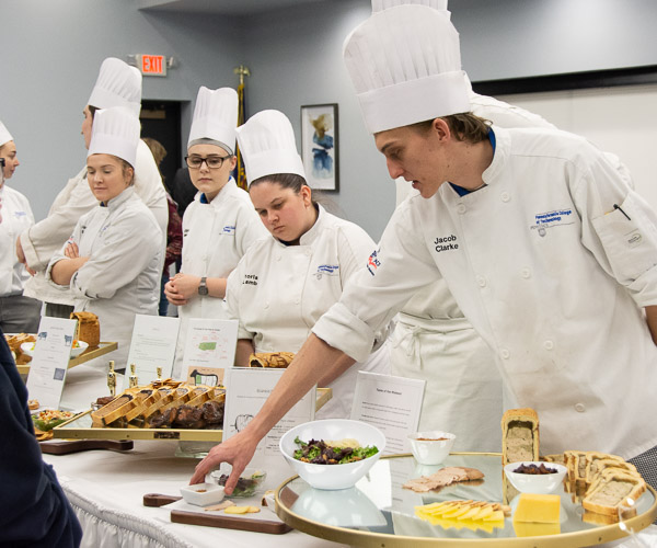 Jacob G. Clarke (right), of Wilmington, Del., answers a high school student’s questions about his entry for the Advanced Garde Manger course.