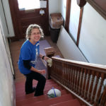 Stephanie A. Campbell, acquisitions and outreach specialist at Madigan Library, scrubs a staircase.