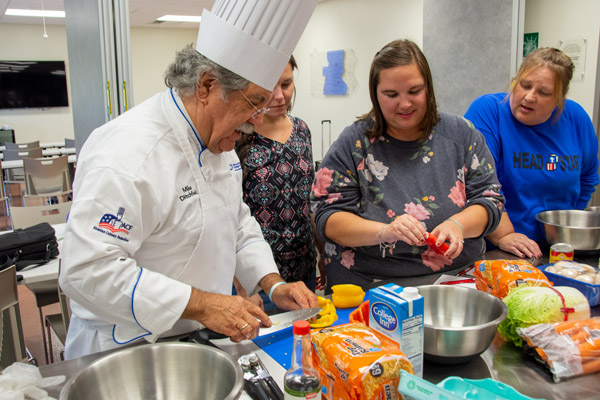 Chef Michael J. Ditchfield, instructor of hospitality management/culinary arts, works with a team of Head Start employees.