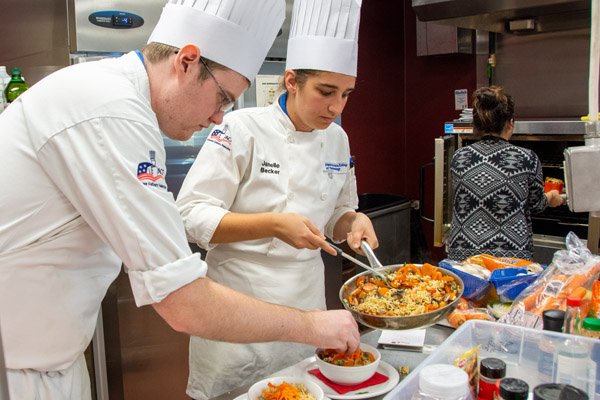 Culinary arts and systems students Christopher J. Schreckengost and Janelle R. Becker plate their competition dish.
