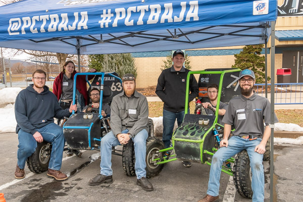 Members of the Baja SAE club, who have competitively garnered international attention for their alma mater, pose with their two vehicles.