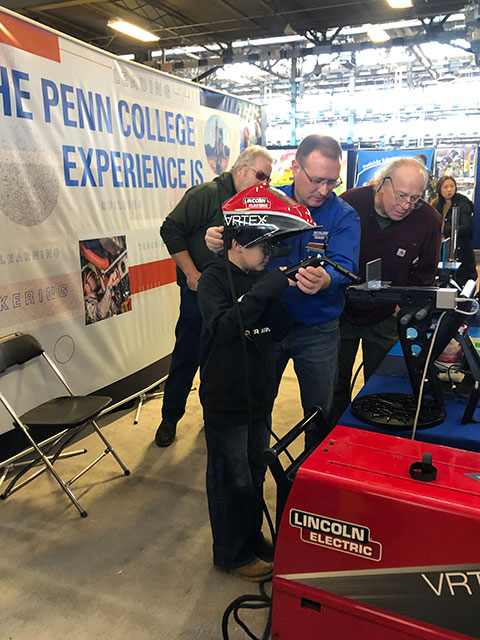 Instructor James C. Tanner guides a guest in a virtual reality welding challenge.