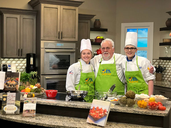 June (right) and culinary arts technology major Madison P. Erb, of Montgomery, on set with former Penn College Visiting Chef Walter Staib
